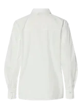 Camisa blanca de corte holgado, con cuello clásico, mangas largas con puños abotonados y cierre frontal con cremallera.
