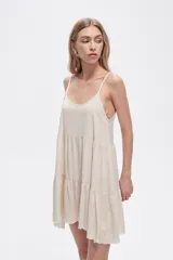 Vestido corto color crema, de lino y algodón, con breteles finos y corte holgado.