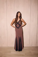 Vestido largo de seda color marrón con estampado de lunares blancos y detalles de encaje negro. Presenta un diseño entallado en el torso, escote en V profundo y espalda descubierta con tiras cruzadas.