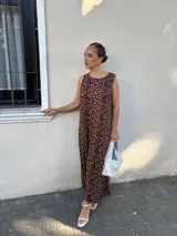 Vestido largo azul marino de tejido acanalado, con escote redondo y mangas cortas tipo hombrera. Presenta una abertura lateral en la falda.