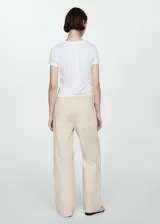 Pantalón color crema de corte recto, con cintura elástica ajustable con lazo, bolsillos cargo y bolsillos de parche en la parte posterior.