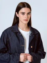 Chaqueta de denim azul oscuro con cuello de piel sintética color borgoña, cierre frontal con botones a presión, bolsillos de parche con solapa en el pecho y bolsillos laterales.