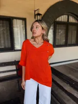 Blusa celeste de lino con cuello en V, mangas cortas con dobladillo y cierre lateral con botones de madera.