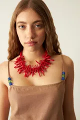 Vestido corto negro con tirantes finos y escote cuadrado. Toda la superficie del vestido está cubierta con pequeñas aplicaciones de pedrería.