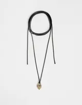 Gargantilla con cordón negro y dije de corazón dorado cubierto de strass multicolor.