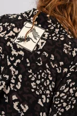 Camisa tipo camisola con estampado animal print en tonalidades negras y crudas, de manga corta y corte holgado.