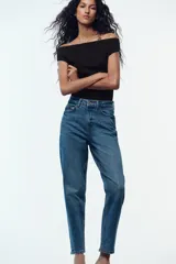 Jeans de tiro alto color celeste, corte mom fit, con cinco bolsillos y cierre frontal con cremallera y botón.