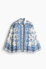 Camisa de corte holgado en tejido liviano de mezcla de viscosa. Modelo de hombros caídos con cuello, mangas largas holgadas, botonadura frontal y bajo recto. Estampado con motivos florales y cachemir en tonos azules y blancos.