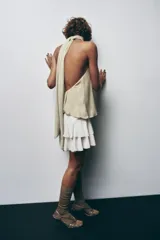 Top de cuello halter color beige, con lazada tipo foulard, forro interior y cierre lateral con cremallera oculta.