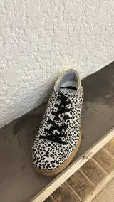 Zapatillas bajas de cuero negro con cordones y suela de goma color caramelo.