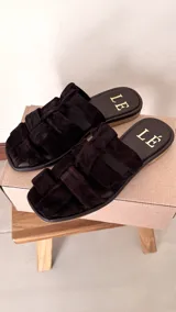 Sandalias bajas color rosa viejo con tiras de cuero entrelazadas y suela marrón.