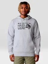 Buzo canguro gris melange con capucha y bolsillo canguro frontal. Estampado frontal con el logo de Mountain Hardwear en negro.