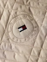 Chaquetón acolchado color beige con diseño de rombos, doble botonadura, cinturón y mangas con vuelta.