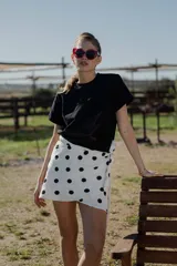 Minifalda pareo blanca con estampado de lunares negros y lazo lateral.