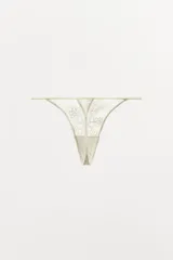 Tanga color crema de encaje floral con cintura elástica.