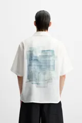 Camisa verde agua con estampado abstracto, corte relaxed fit, cuello solapa, manga corta y cierre frontal con botones.