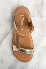 Sandalias de cuero color marrón y dorado, con plataforma y hebilla ajustable.