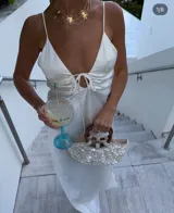 Bolso de mano con forma de media luna cubierto de perlas sintéticas. Tiene asas circulares de madera y detalles de cuentas en la unión con el cuerpo del bolso.