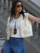 Chaleco color natural con bordados de flores en hilo color beige.