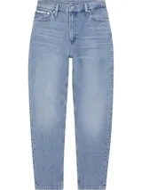 Pantalón de jean celeste de corte mom, tiro alto, cinco bolsillos y cierre con cremallera.