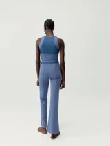 Calza larga acampanada color negro, de tejido Skin_Move ligero y resistente. Cinturilla ancha doble tejido y pieza decorativa en tejido de malla transpirable.