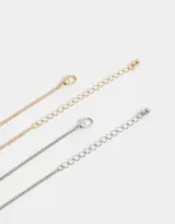 Set de dos collares con cadena plateada y dorada, con dijes de gato dorado con strass y perro plateado con strass.