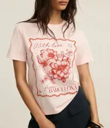 Remera de algodón color rosa con cuello redondo y mangas cortas. Estampa frontal con moldura, flores y texto "With love from Barcelona".