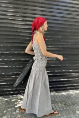 Falda larga gris con finas rayas verticales blancas, de tiro alto y corte acampanado.