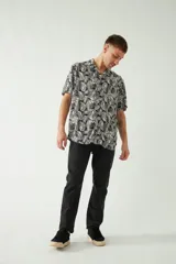Camisa celeste con estampado de hojas, de corte slim, manga corta, cartera abotonada y logo bordado.