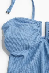 Traje de baño entero celeste con textura acanalada, breteles regulables y escote en U con detalle de abertura.