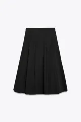 Falda midi negra de tiro alto con detalle de tablas en el delantero y cierre lateral con cremallera oculta.