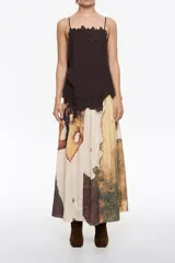 Falda midi de corte línea A con vuelo, confeccionada en poliéster. Presenta un estampado abstracto en tonos tierra, beige, marrón y verde musgo. Tiene cremallera lateral invisible y pliegues irregulares cosidos en la cintura.