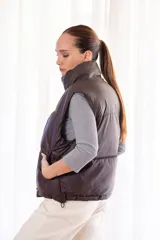 Chaleco acolchonado negro para dama, con cierre frontal y bolsillos laterales.