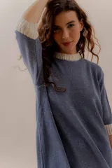 Vestido corto tejido en punto color negro con cuello, puños y ruedo en blanco.