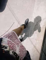 Botas cortas negras de cuero con bordados blancos estilo cowboy.