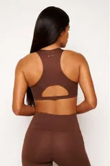 Top deportivo negro con diseño nadador, entrada para almohadillas removibles, bolsillo trasero y detalle reflectivo.