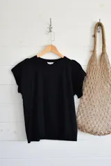 Remera blanca de corte regular, con mangas cortas y detalles de fruncido en los hombros.