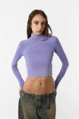 Top de morley de algodón color lila, de mangas largas con mitones para dedo pulgar, cuello alto y recortes en la prenda.