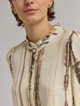 Camisa de viscosa color crema con estampado de rayas verticales en tonos marrones y cuello con volados.