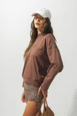 Buzo rojo de cuello alto con la palabra 'Rotunda' bordada en el frente. De corte holgado y mangas largas.