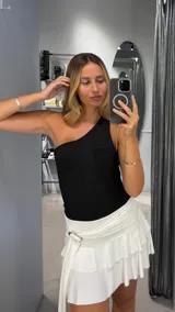 Body negro asimétrico con un solo hombro descubierto.