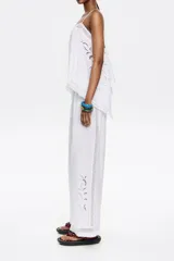 Pantalón blanco de corte ancho con cintura elástica y bordado en la parte inferior de la pierna.