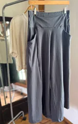 Pantalón palazzo gris oscuro, de tiro alto, confeccionado en algodón deportivo sin felpa. Presenta corte amplio, bolsillos laterales, elástico en la espalda y faja ancha.