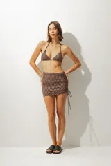 Minifalda de playa con estampado a rayas verticales azules y negras, con cordones laterales ajustables.