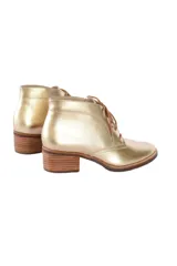 Botines acordonados de cuero dorado metalizado con tacón bloque de 6 cm y cordones marrones.