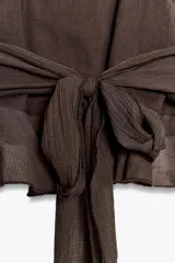 Top verde esmeralda con cuello halter, volantes en el frente y espalda descubierta con lazo.