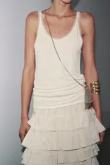 Musculosa blanca de breteles finos y escote redondo con detalle de tul a tono.