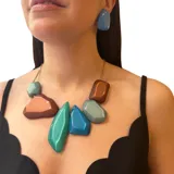 Collar de resina multicolor con formas geométricas irregulares y cadena dorada.