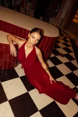 Vestido largo color borgoña, con escote drapeado y cuello halter. Tiene forro corto con transparencia.