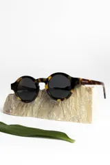 Lentes de sol redondos con montura de carey y lentes oscuros.